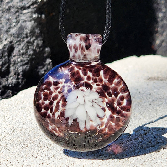 Heady Blown Glass Pendant – Handmade White and Black Glass Necklace with crushed glass texture and floral center, displayed on stone background.
