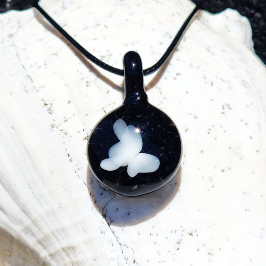 Small black and white glass pendant featuring a white butterfly design, handmade in the USA. Unique statement jewelry for gifting or daily wear.