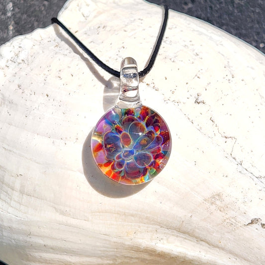 Unique Purple & Blue Glass Pendant – Handmade Borosilicate Jewelry featuring a vibrant flower design with red, blue, and purple hues on a shell.