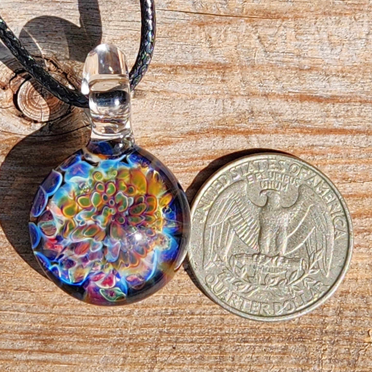 Ocean Reef Glass Pendant Necklace next to US quarter for size comparison, highlighting detailed multicolor reef design and clear glass loop.