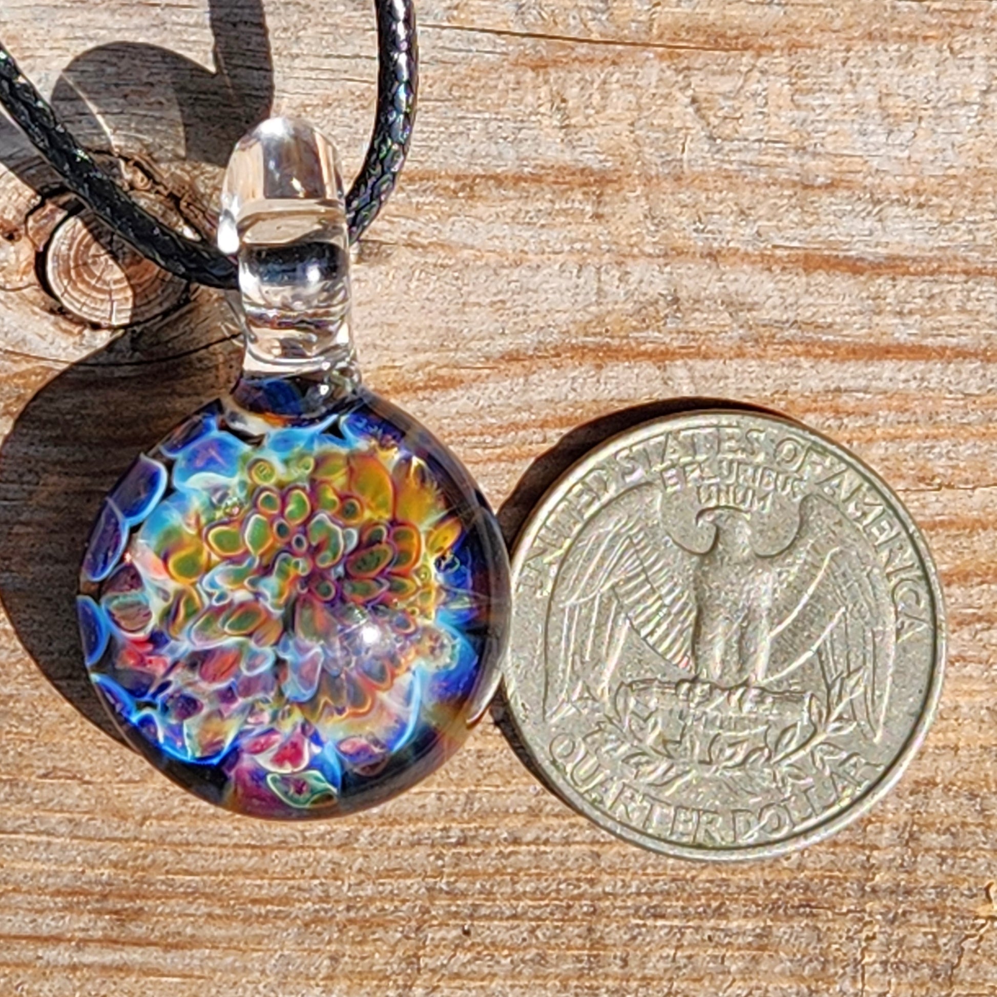 Ocean Reef Glass Pendant Necklace next to US quarter for size comparison, highlighting detailed multicolor reef design and clear glass loop.