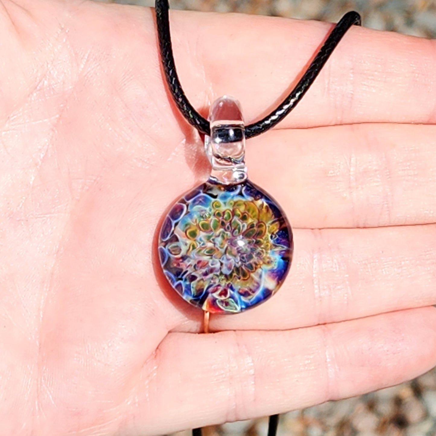 Ocean Reef Glass Pendant Necklace held in hand, showing scale and intricate handmade reef design in vibrant oceanic colors.