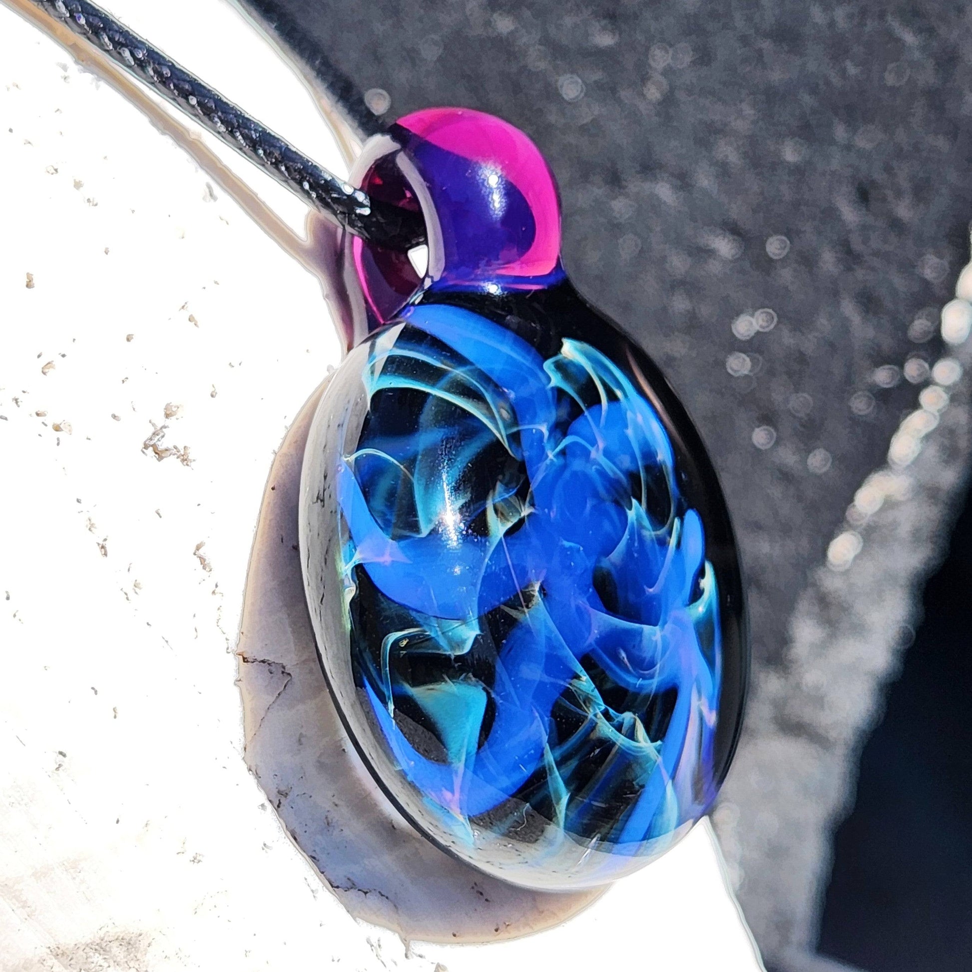 Side view of Handmade Blue Swirl Glass Pendant Necklace showing intricate color-shifting swirls and glossy finish.