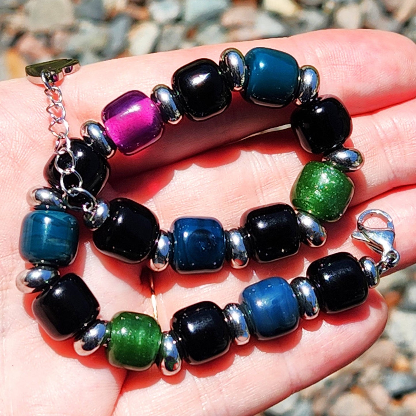 Vibrant handmade Boho Glass Beaded Bracelet held in hand, featuring multicolor glass beads and silver-toned accents.