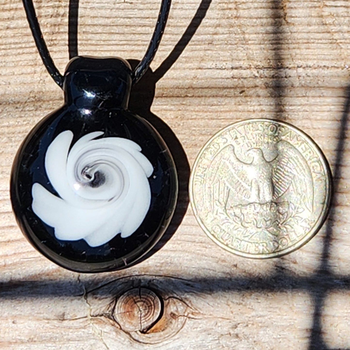 Size comparison of Black and White Swirl Glass Pendant | Handmade Necklace Jewelry Gift next to a US dollar coin, showing its small, wearable size.