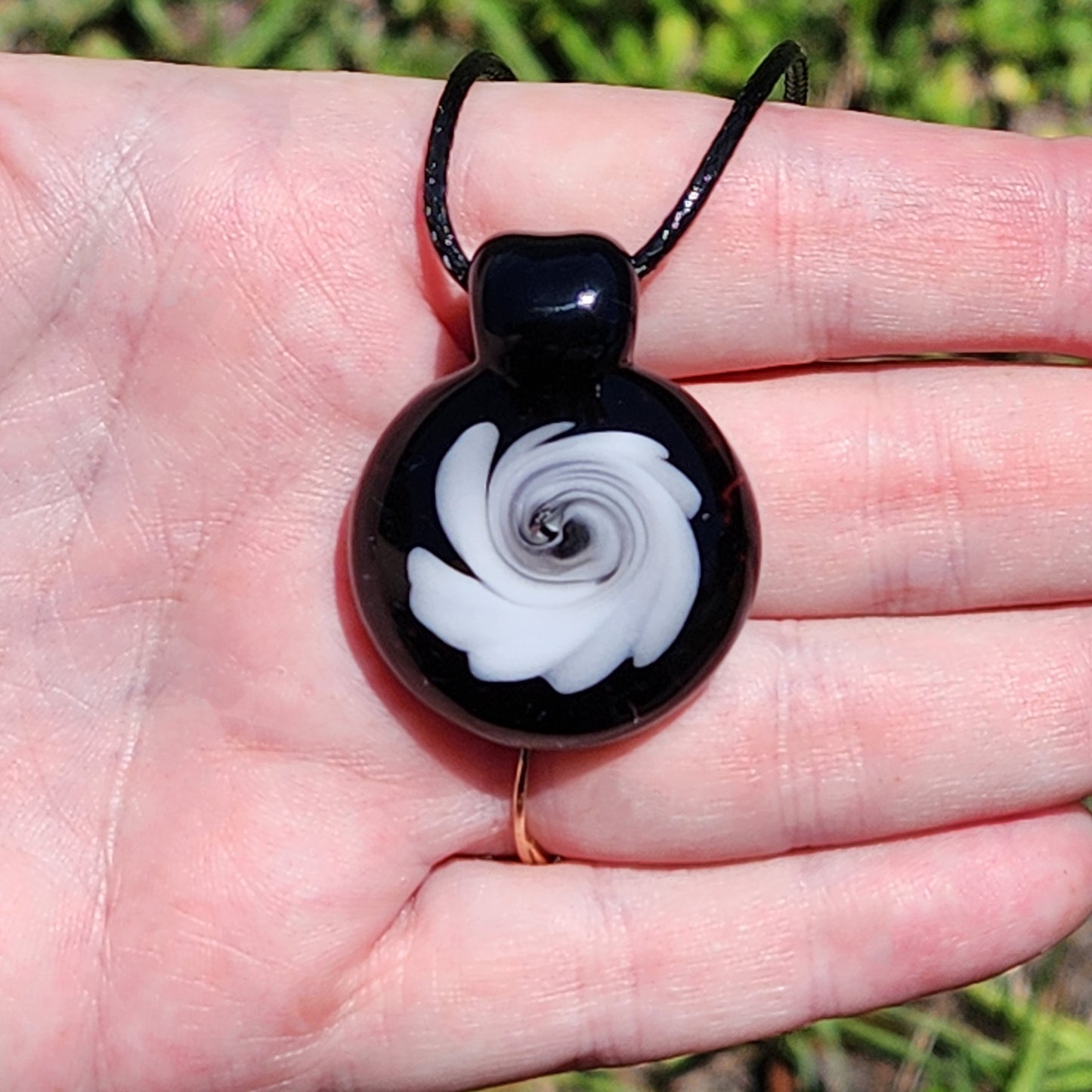 Black and White Swirl Glass Pendant | Handmade Necklace Jewelry Gift shown in hand, highlighting its wearable size and artistic glasswork.