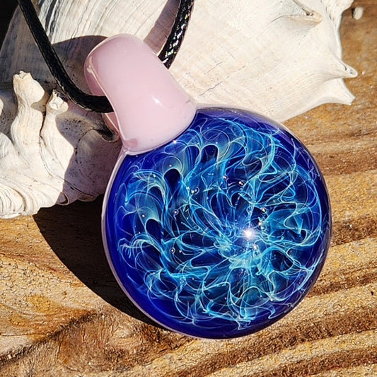 Heady glass pendant necklace featuring a swirling blue design with silver fuming, set on a pink loop. Handmade jewelry for women.