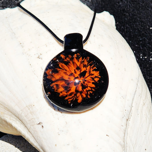 Fiery Glass Pendant Necklace featuring a vivid orange and red fire bloom design on black glass. Handmade Halloween-inspired jewelry for fall fashion.