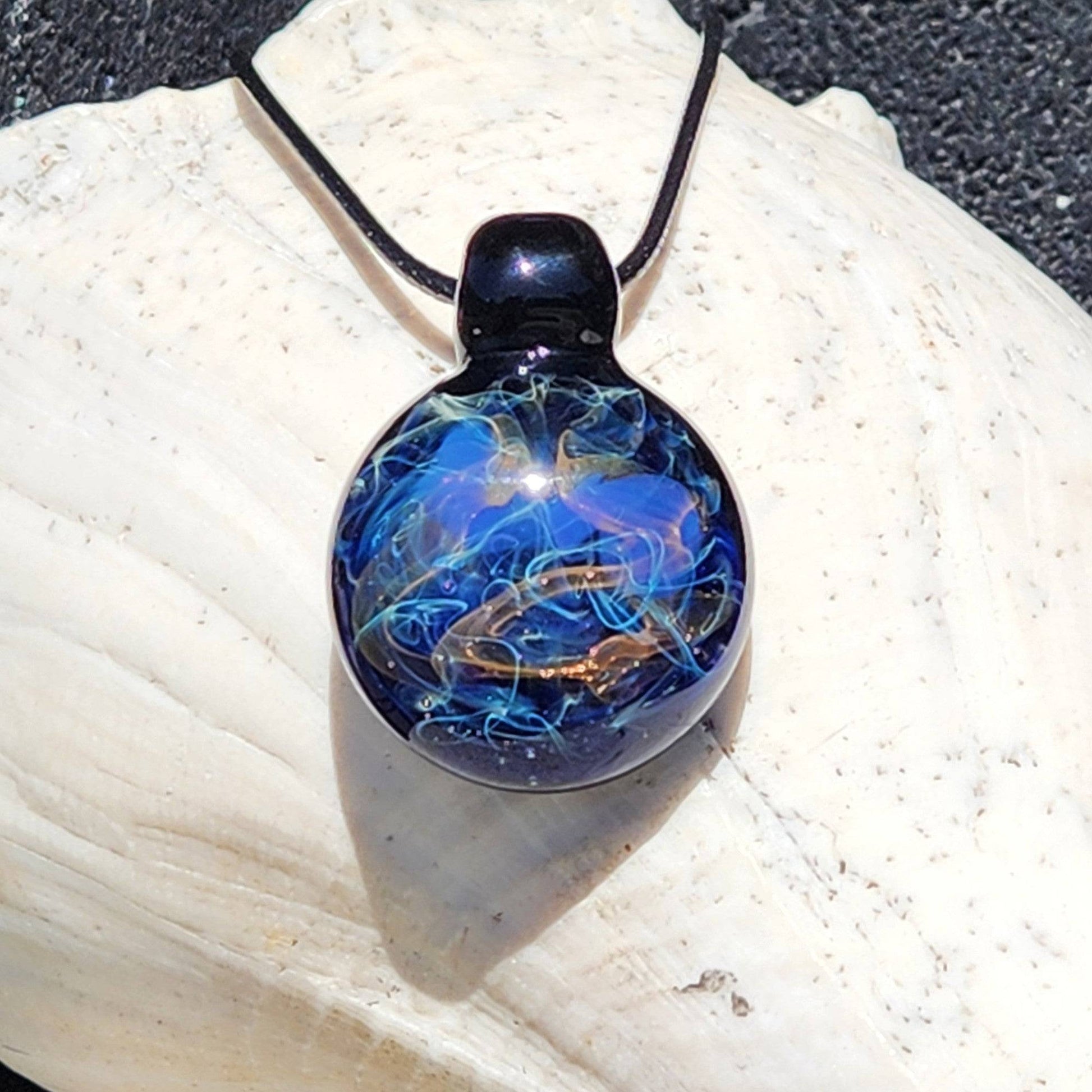 Handmade Glass Pendant – Unique Gold & Silver Fumed Black Necklace with swirling galaxy design on seashell background.