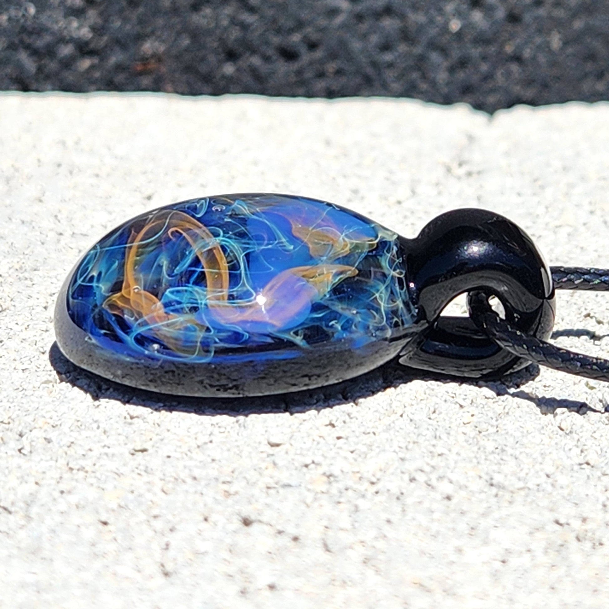 Side profile of Handmade Glass Pendant – Unique Gold & Silver Fumed Black Necklace with glowing fume effects.