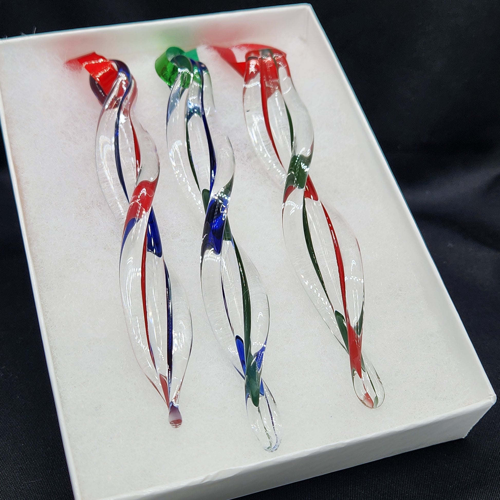 Set of 3 handmade glass ornaments in red, green, and blue swirl design, gift-boxed for holiday giving. Ideal for Christmas tree decor.