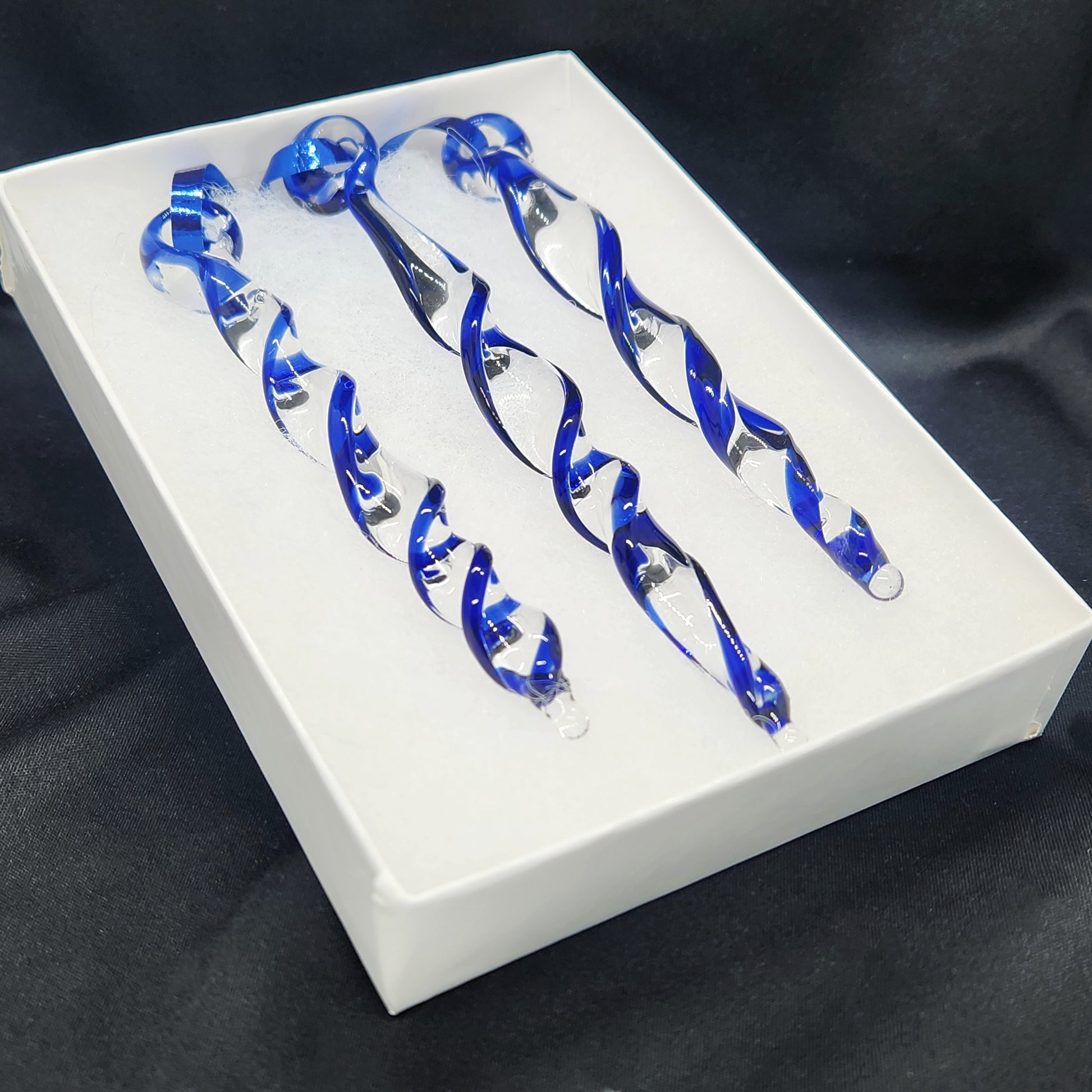 Set of three handmade blue glass Christmas ornaments in a white box. Twisted icicle design perfect for holiday tree or window suncatcher.