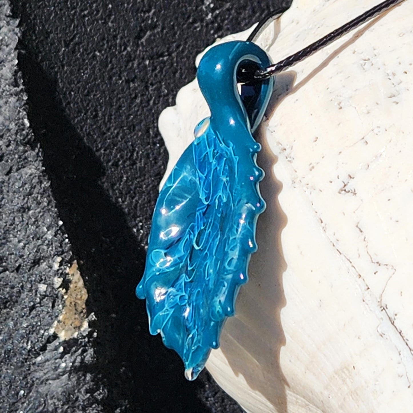 Angled view of Ocean Drift Glass Pendant Necklace with intricate handmade glass design, perfect for ocean-themed fashion accessories.