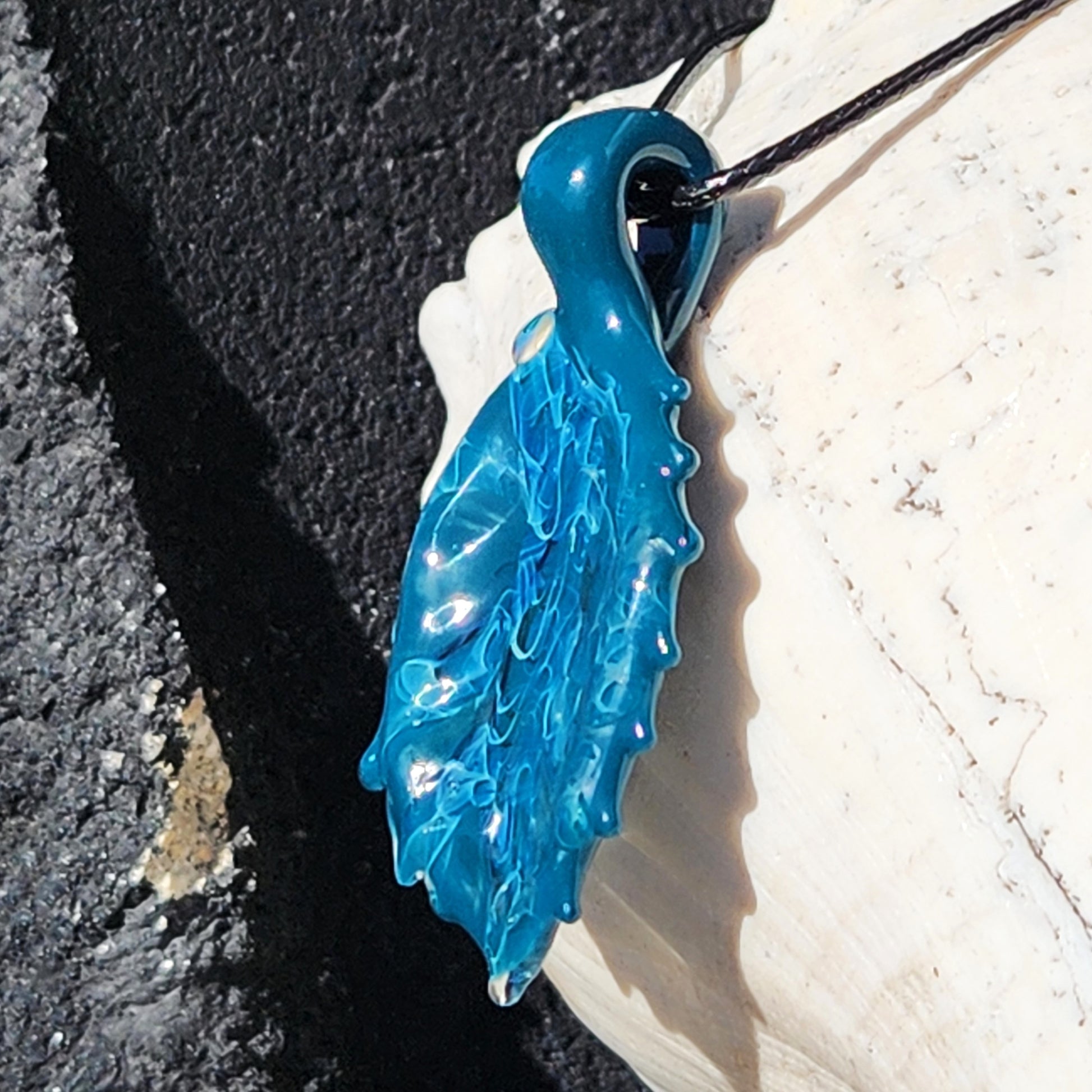 Angled view of Ocean Drift Glass Pendant Necklace with intricate handmade glass design, perfect for ocean-themed fashion accessories.