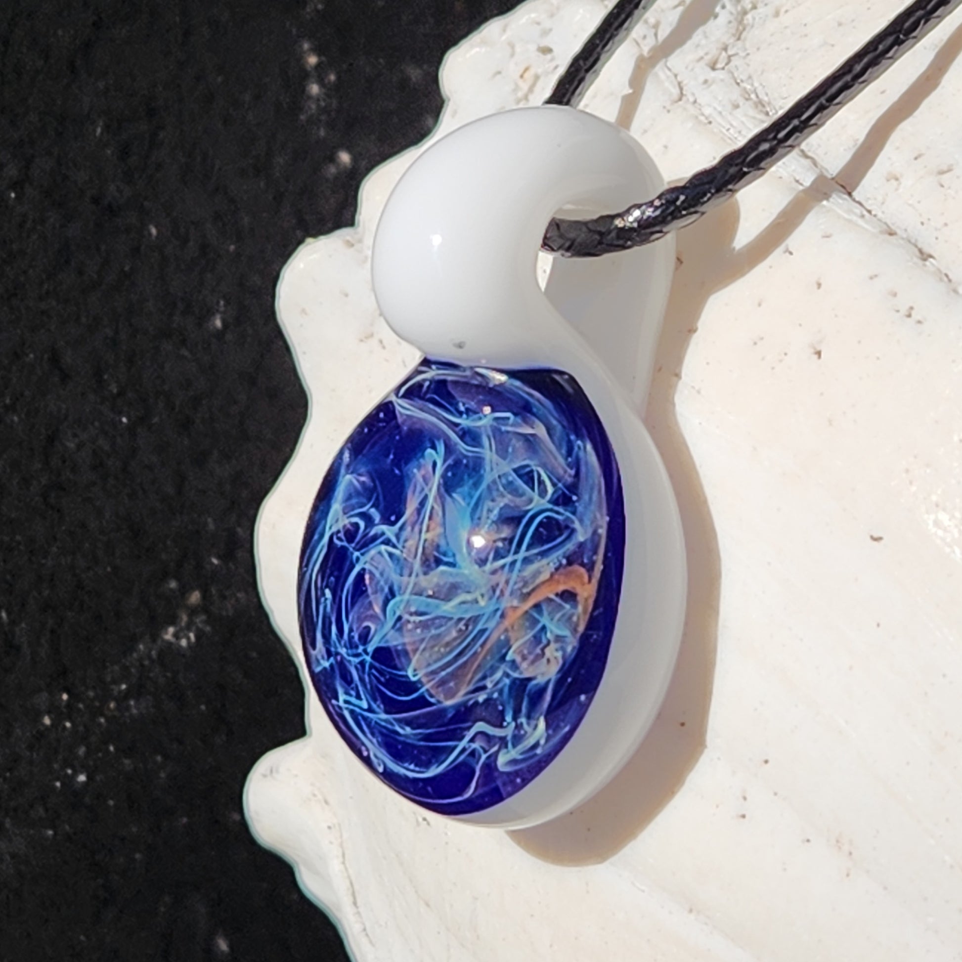 Close-up of Deep Blue Galaxy Pendant Necklace with white glass loop and cosmic swirls, perfect for unique jewelry lovers.
