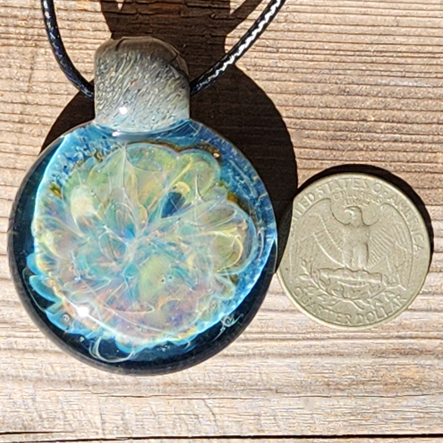 Size comparison of Handmade Glass Pendant Necklace next to a US quarter, highlighting its large, bold design. One-of-a-kind glass jewelry.
