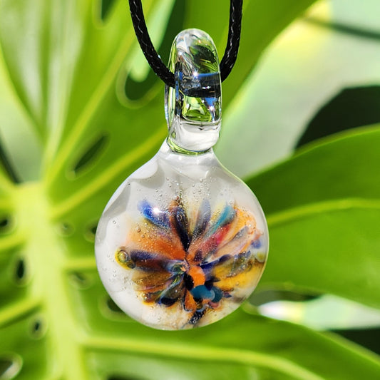Unique colorful glass pendant with rainbow flower design on white background, handmade from borosilicate glass. Boho jewelry on black cord.