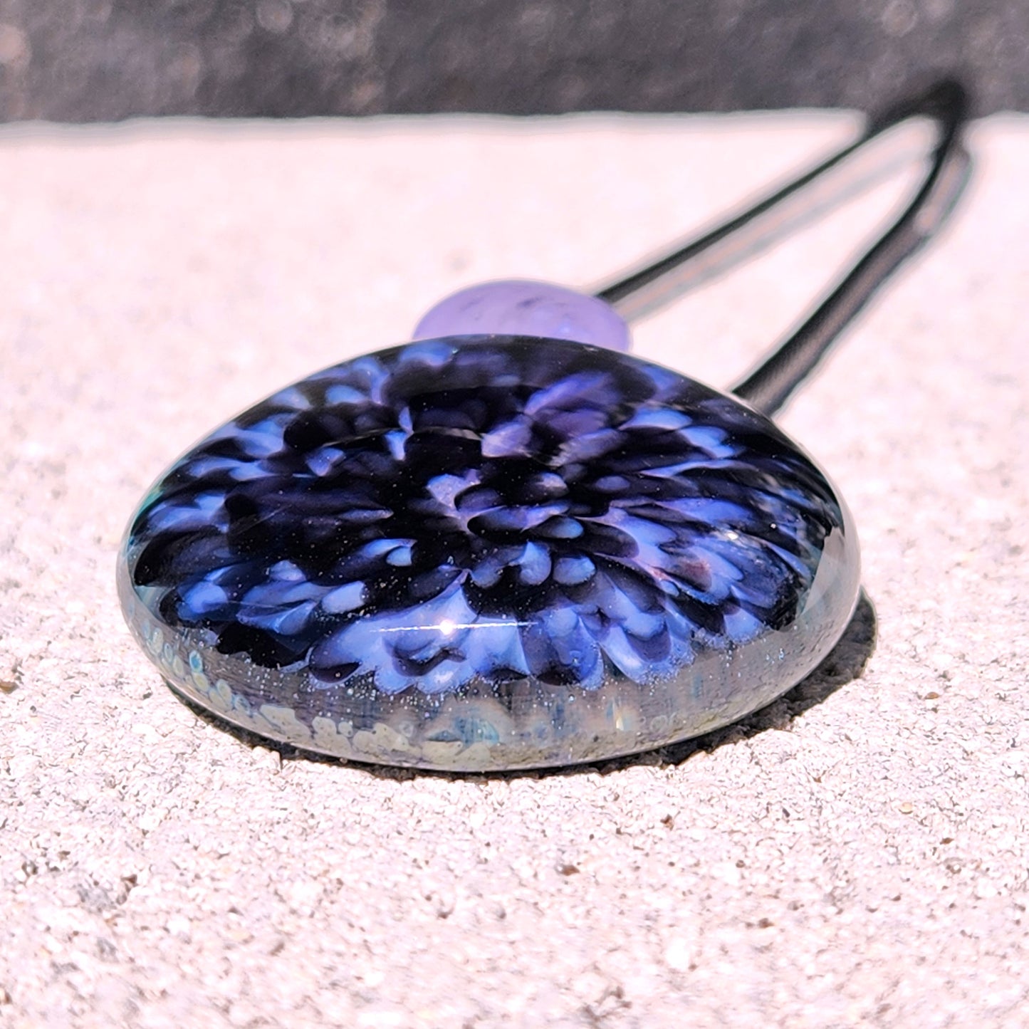Purple Pink Borosilicate Glass Pendant Necklace on a textured surface
