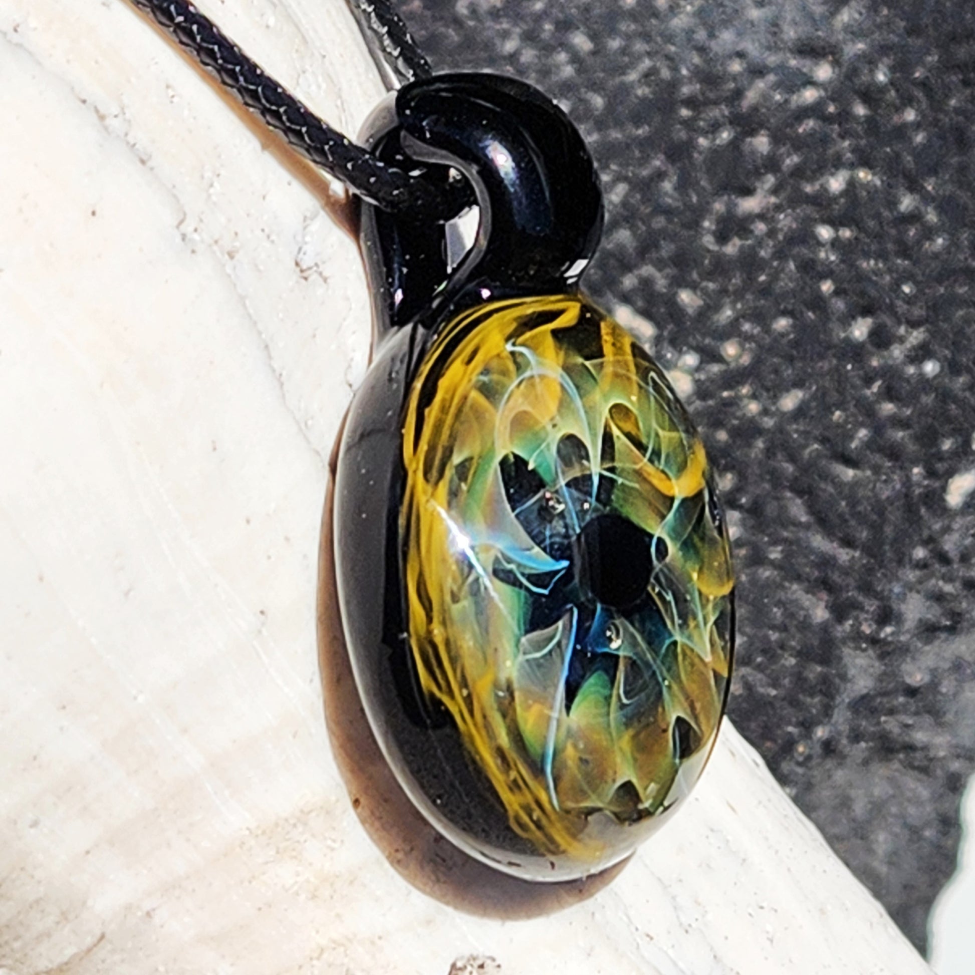 Unique handmade blown glass pendant necklace featuring a galaxy-inspired design in black, blue, and gold. Ideal glass jewelry gift for space lovers.