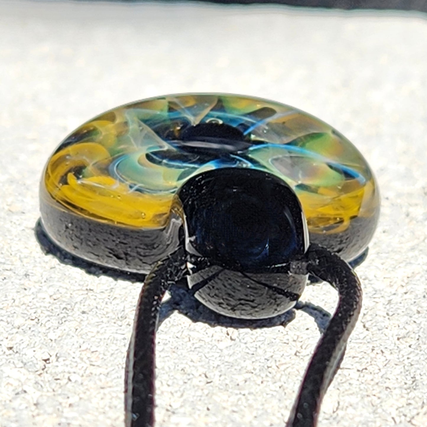 Unique handmade blown glass pendant necklace with swirling galaxy-inspired design in black, blue, and gold. A perfect glass jewelry gift for space lovers.