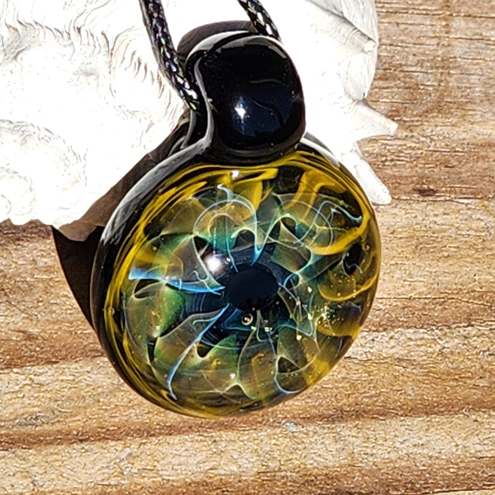 Unique handmade blown glass pendant necklace with swirling black, blue, and gold galaxy design, perfect glass jewelry gift for space lovers.