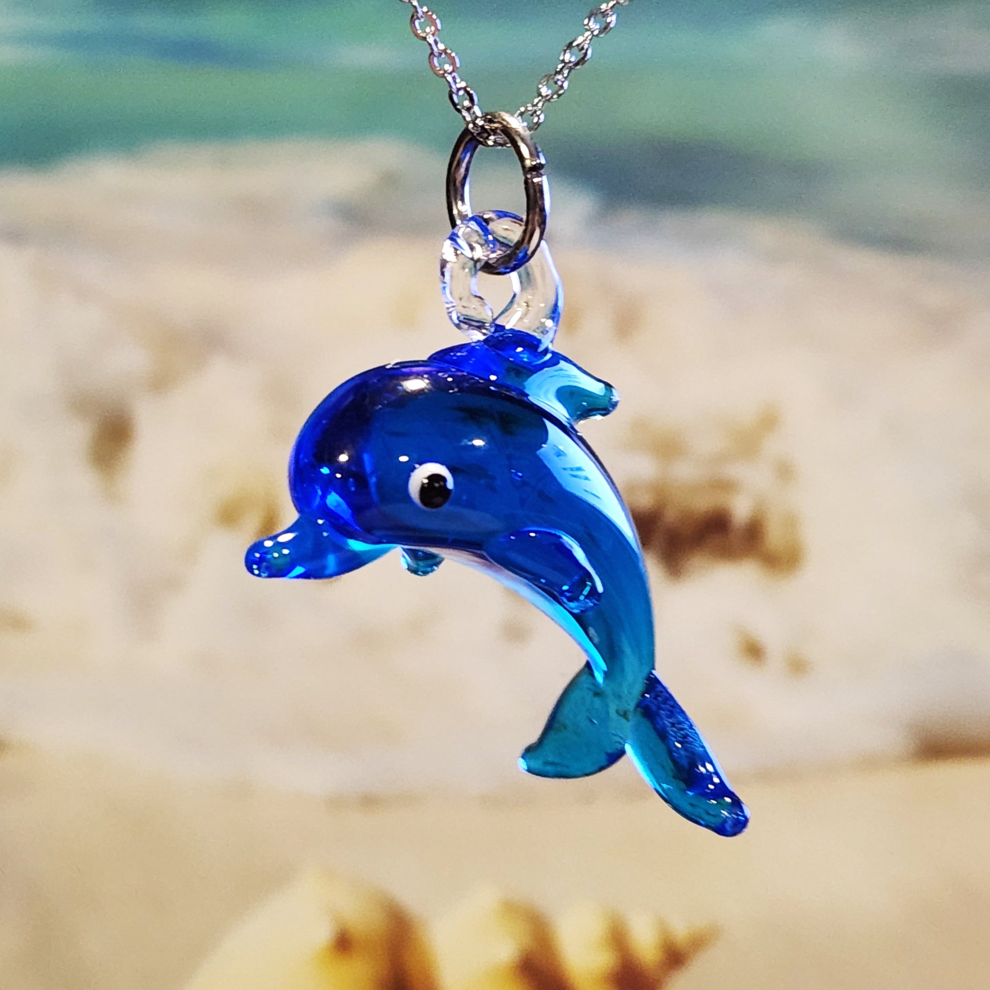 Close-up of blue dolphin glass pendant necklace