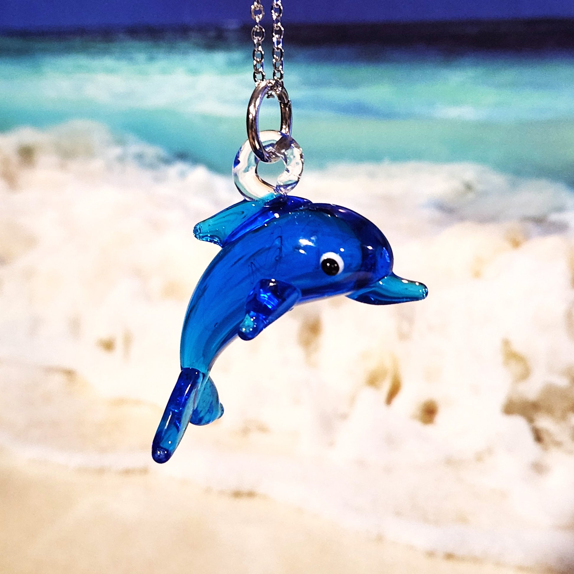Blue dolphin glass pendant necklace with ocean background