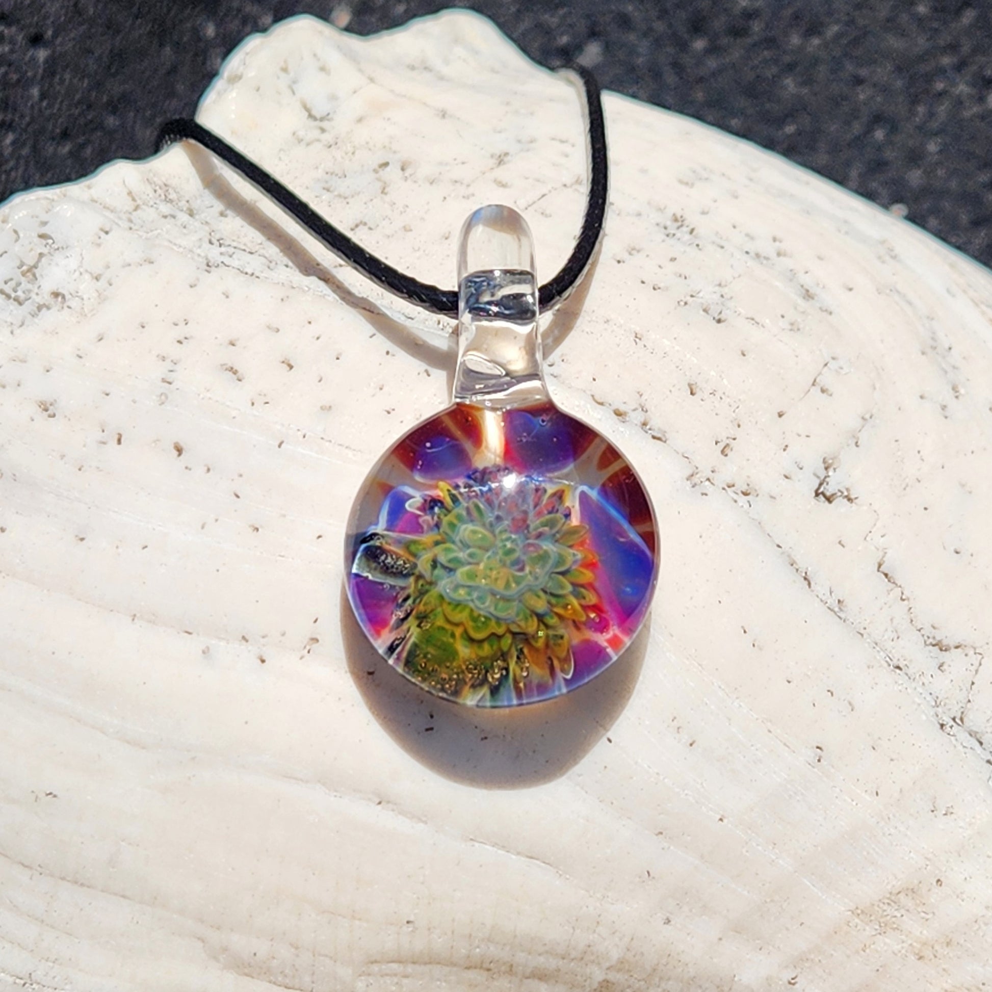 Colorful glass pendant necklace on white coral