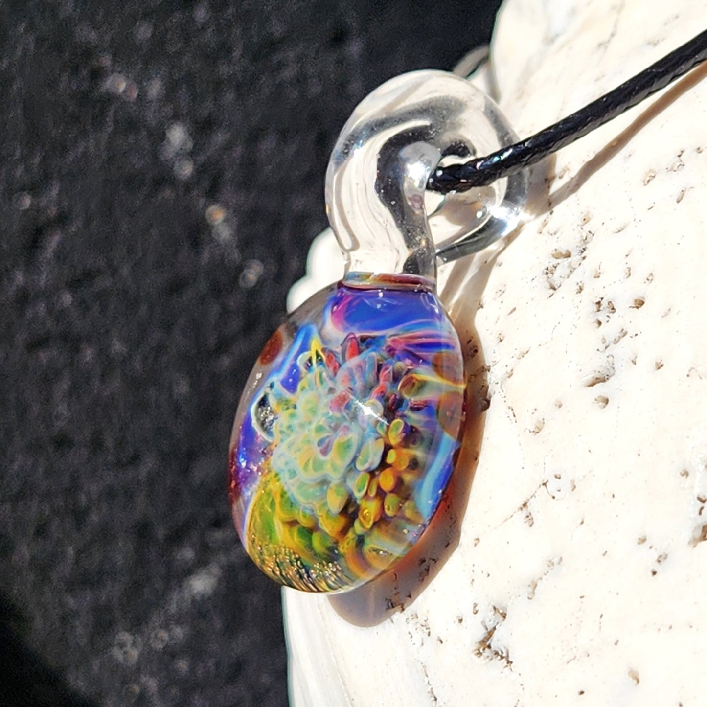 Rainbow glass pendant necklace with adjustable cord on white background