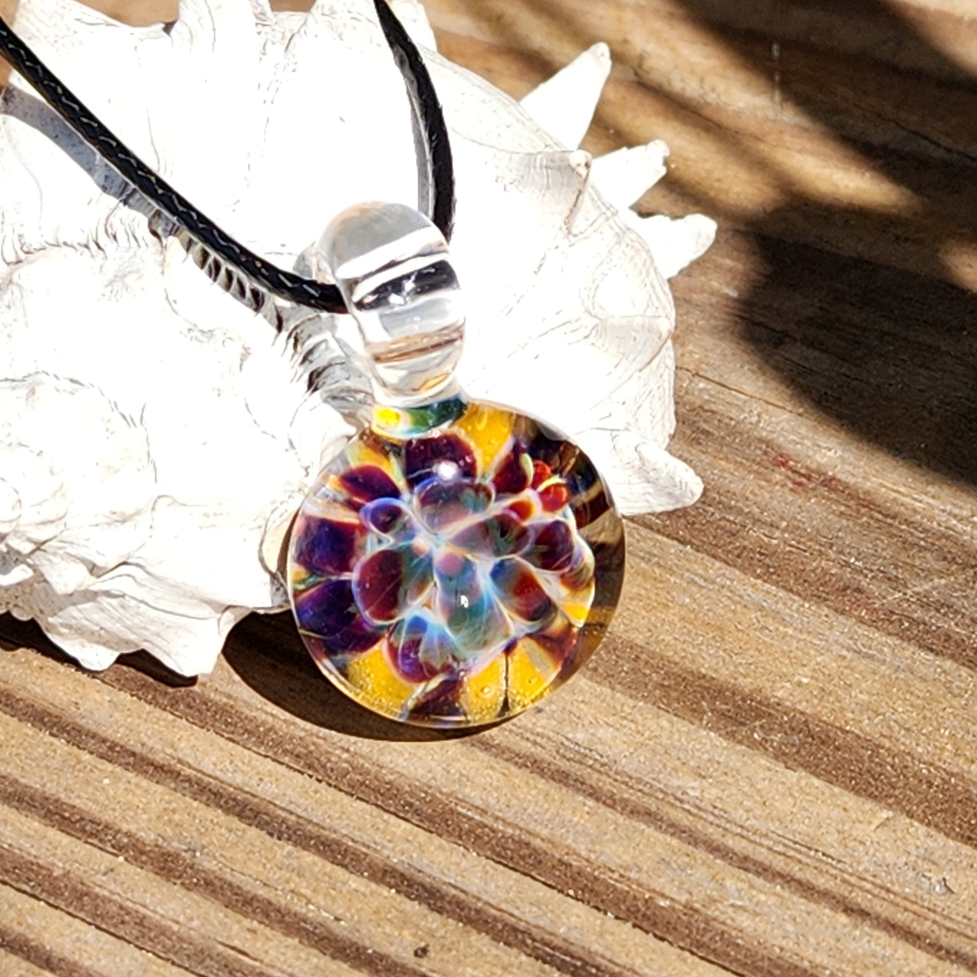 Multicolored glass pendant on a wooden surface