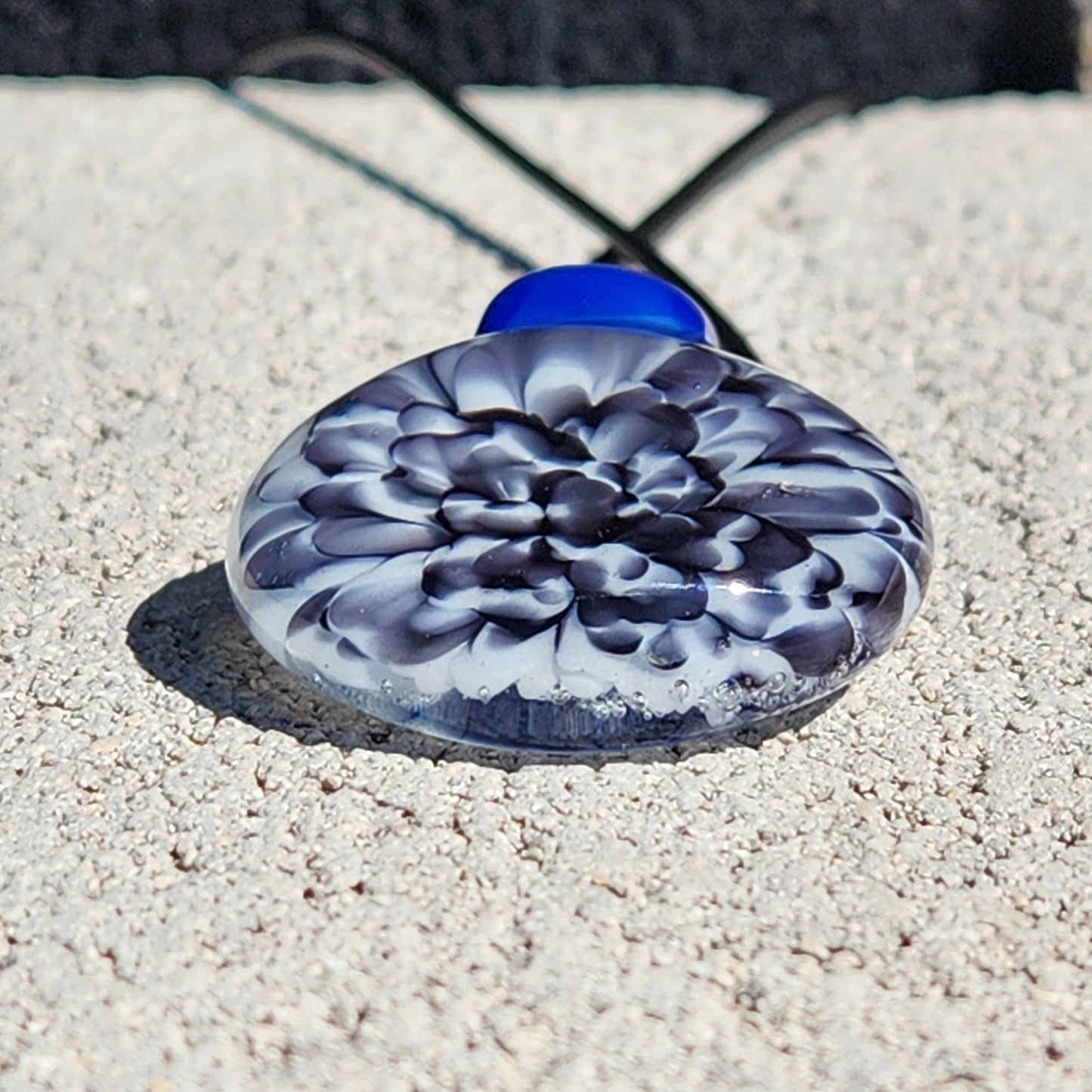 Blue glass pendant on textured surface