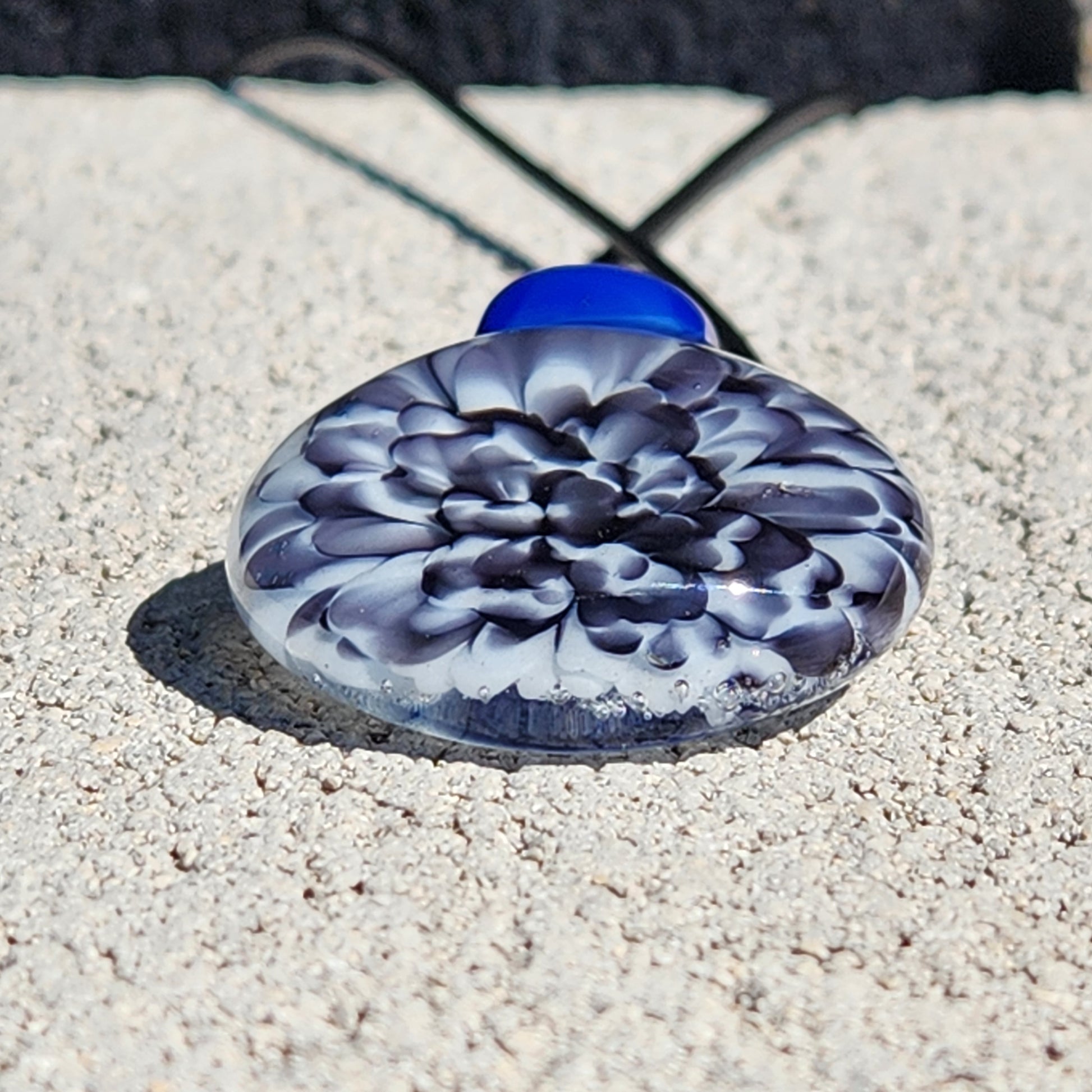 Blue glass pendant on textured surface