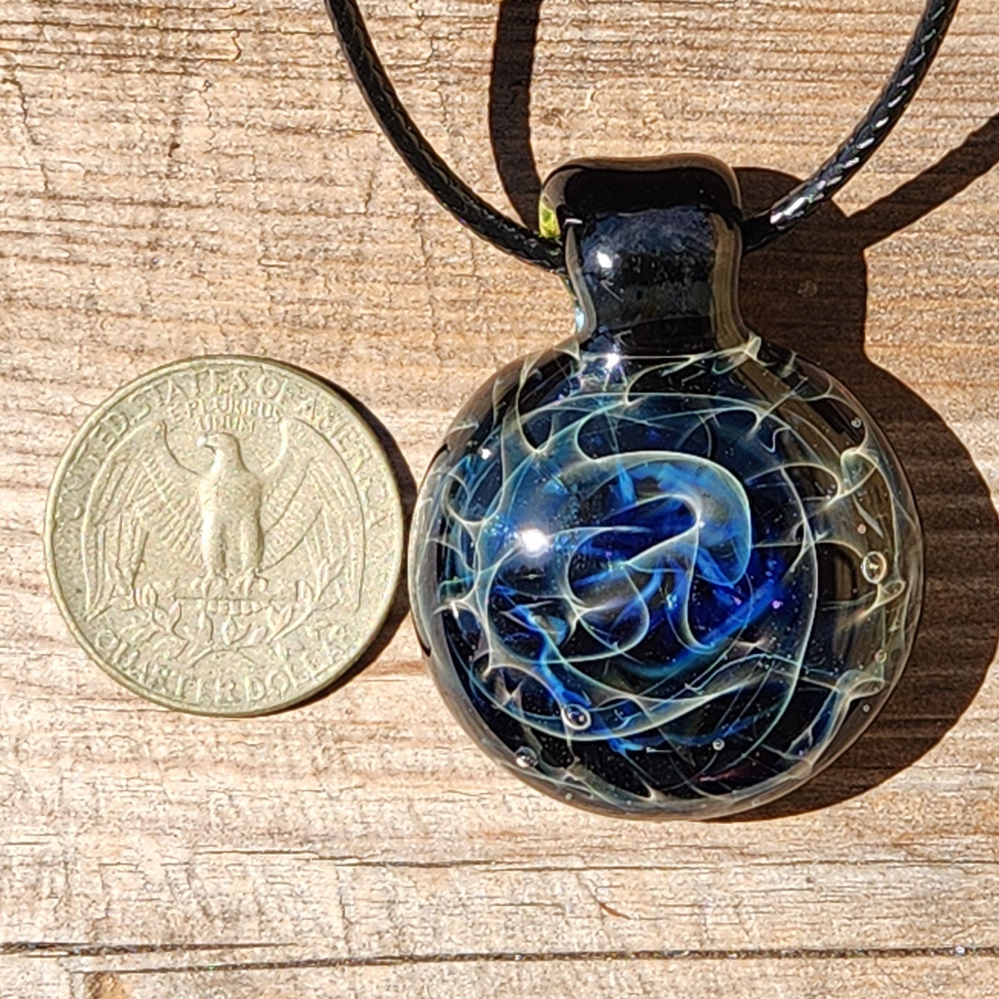 Glass pendant next to a US quarter for size comparison 