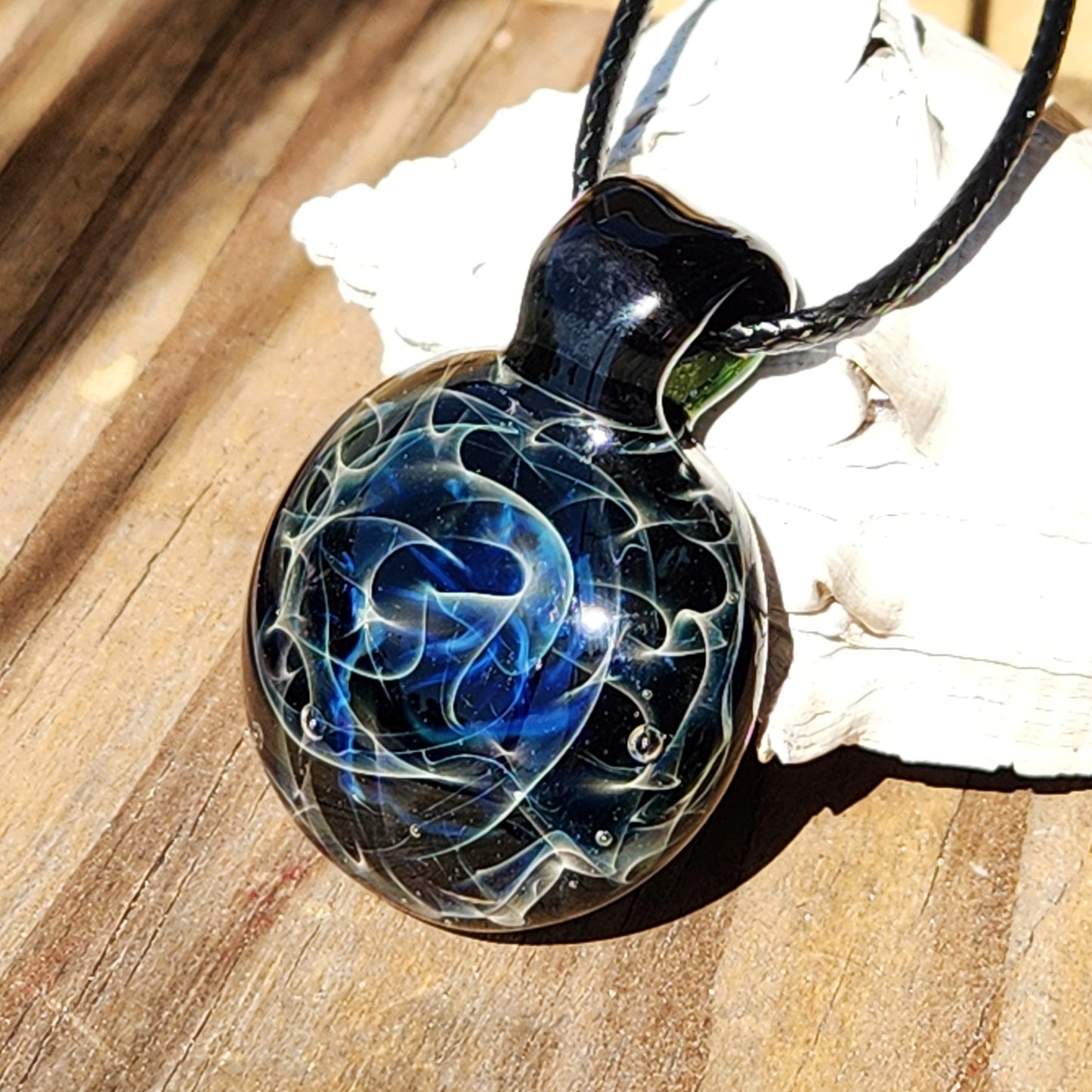 Glass pendant resting on textured surface 