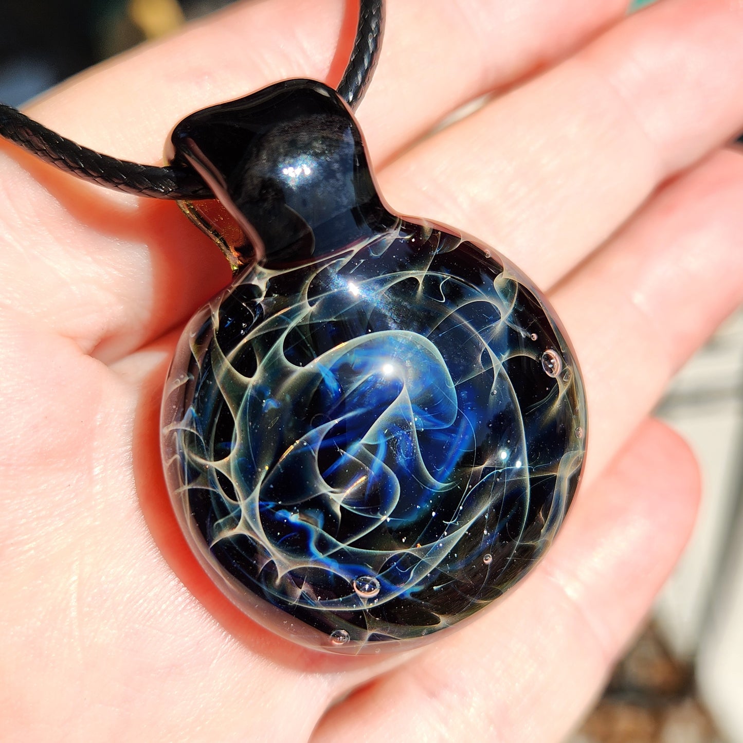 Detailed view of glass pendant showing swirling blue and white design
