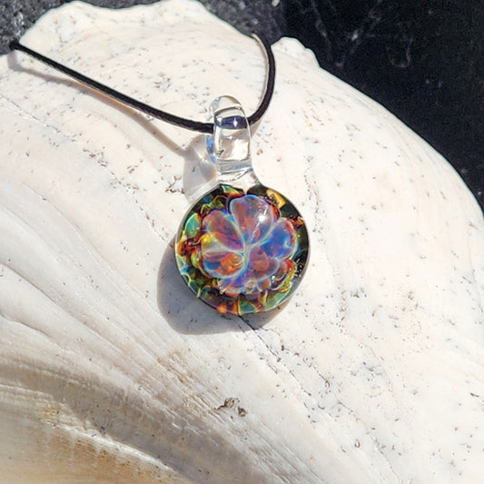 Colorful glass pendant necklace on white textured surface