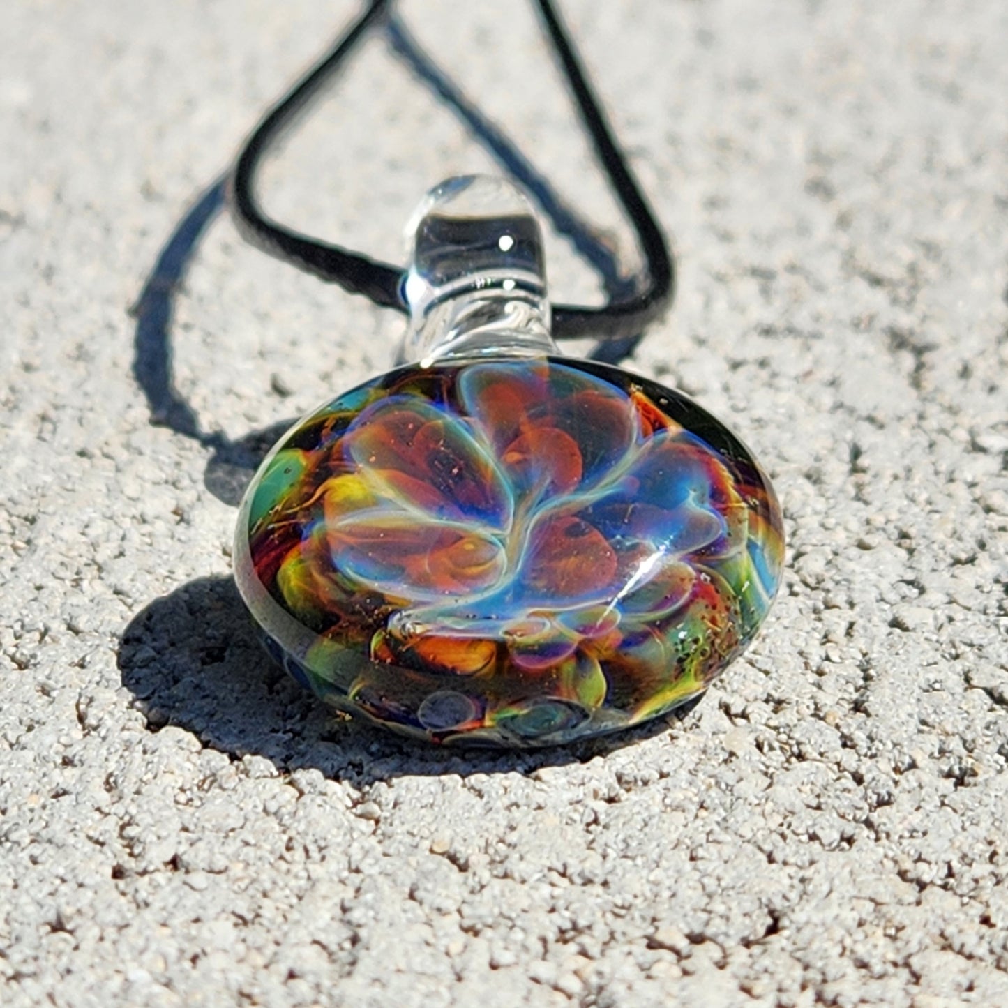 Colorful glass pendant on white textured background