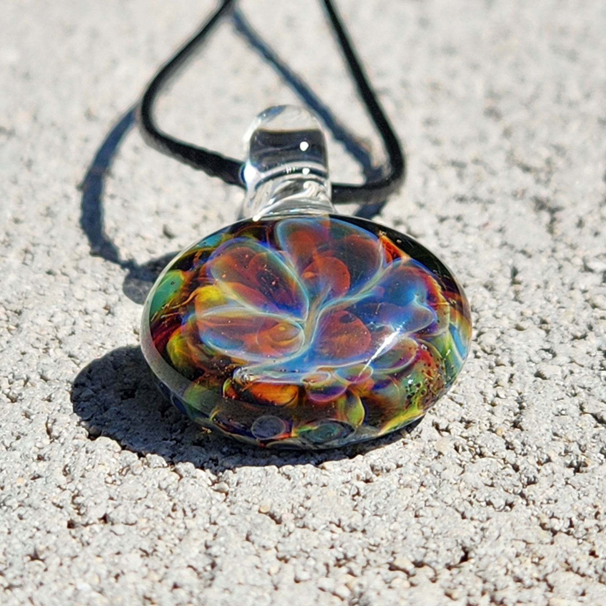 Colorful glass pendant on white textured background