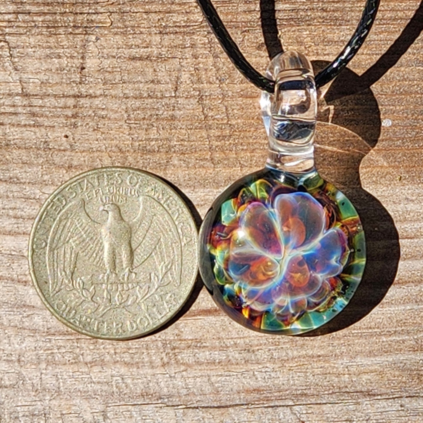 Close-up of glass pendant necklace on wooden background
