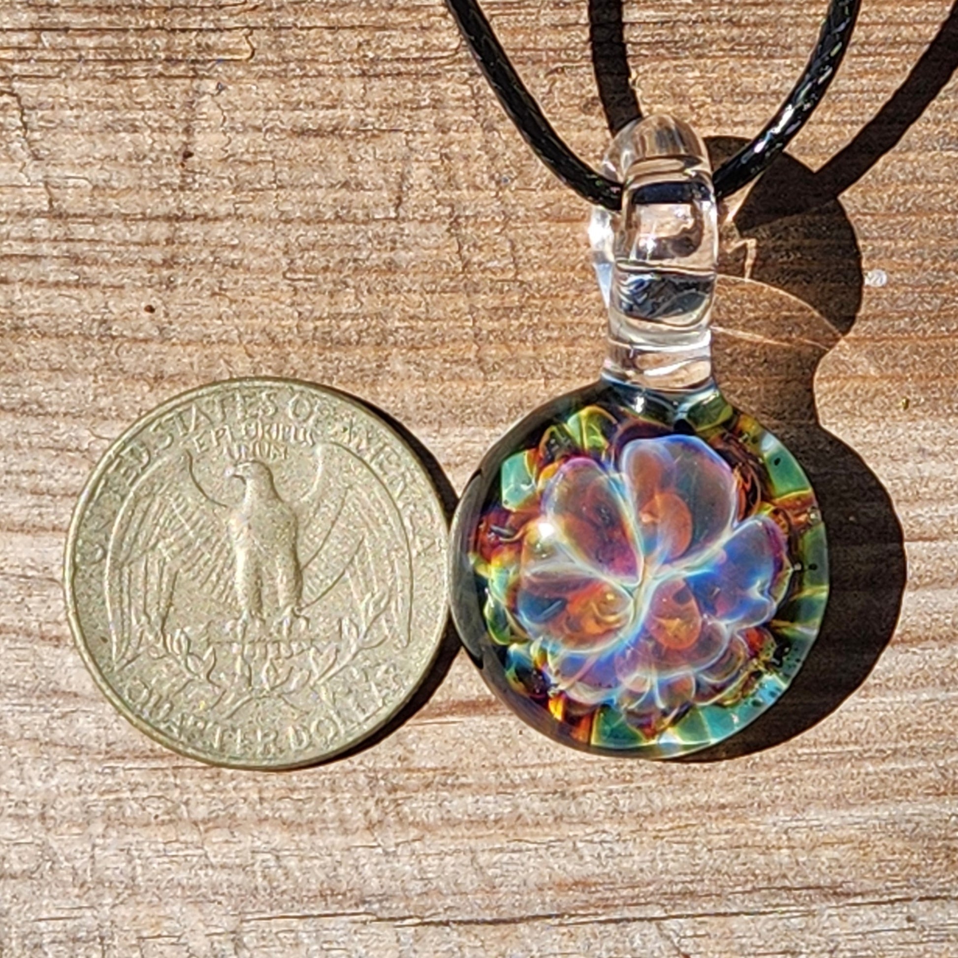 Close-up of glass pendant necklace on wooden background