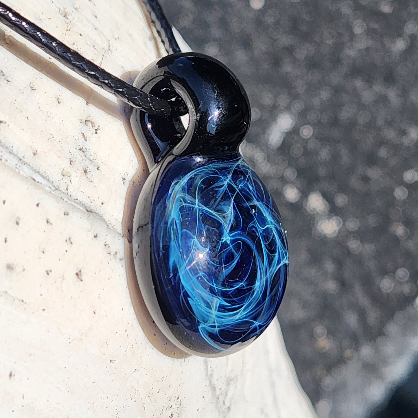 Handmade black glass pendant with intricate blue electric web pattern, artisan jewelry, on adjustable cord, gift box