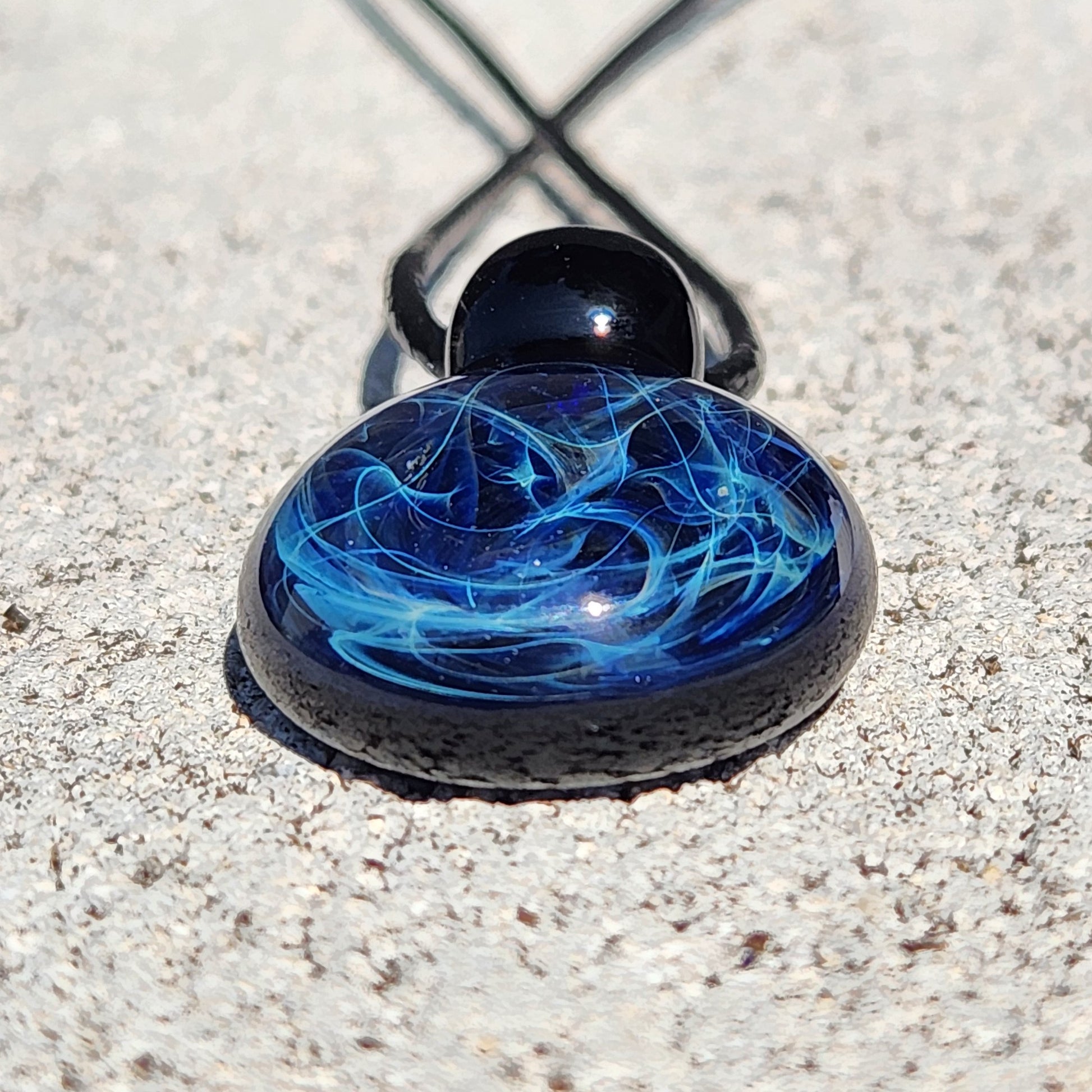 Black glass pendant necklace with blue swirling patterns, handmade artisan jewelry on adjustable cord, gift boxed