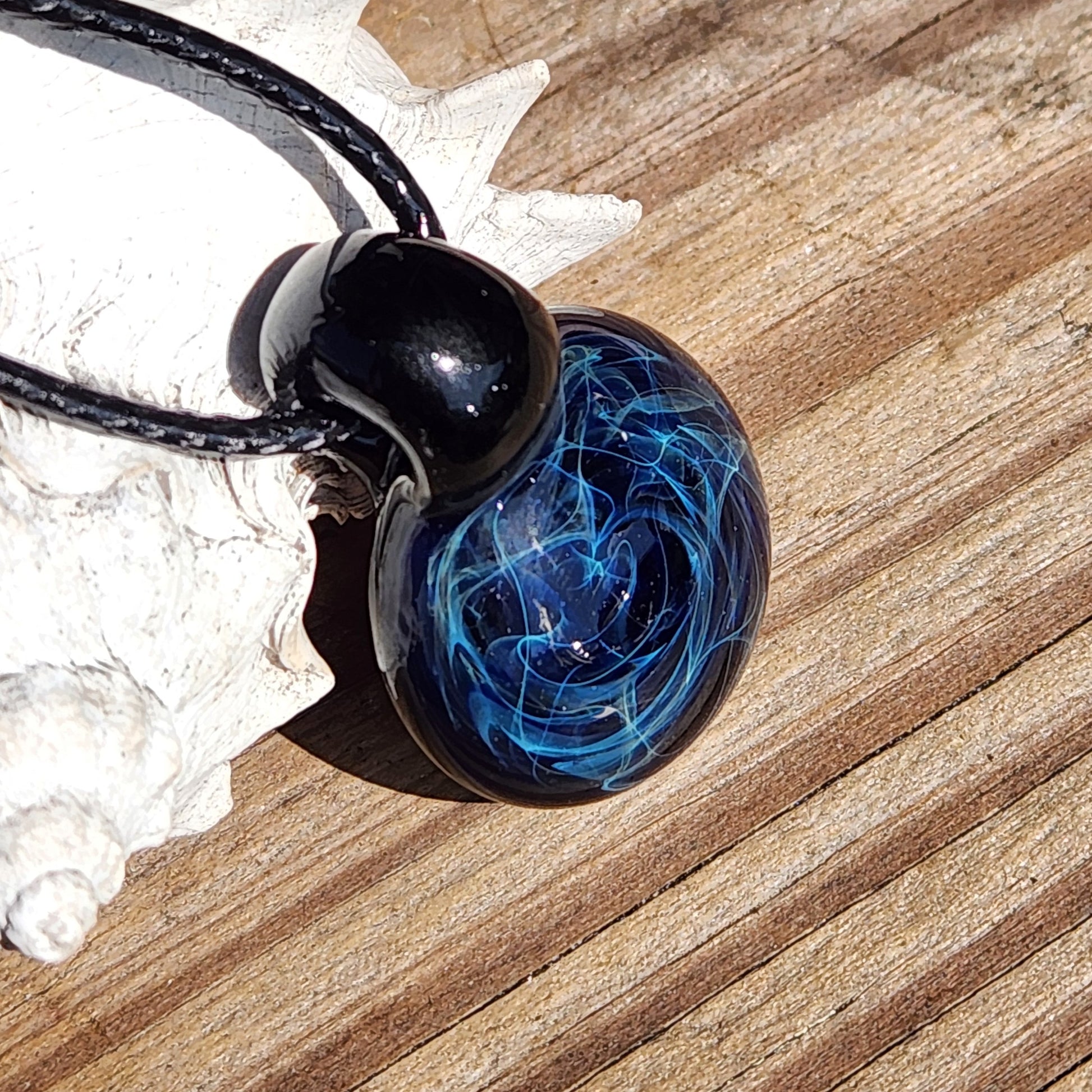Black glass pendant necklace with blue swirling design, artisan handmade jewelry on adjustable cord, gift boxed