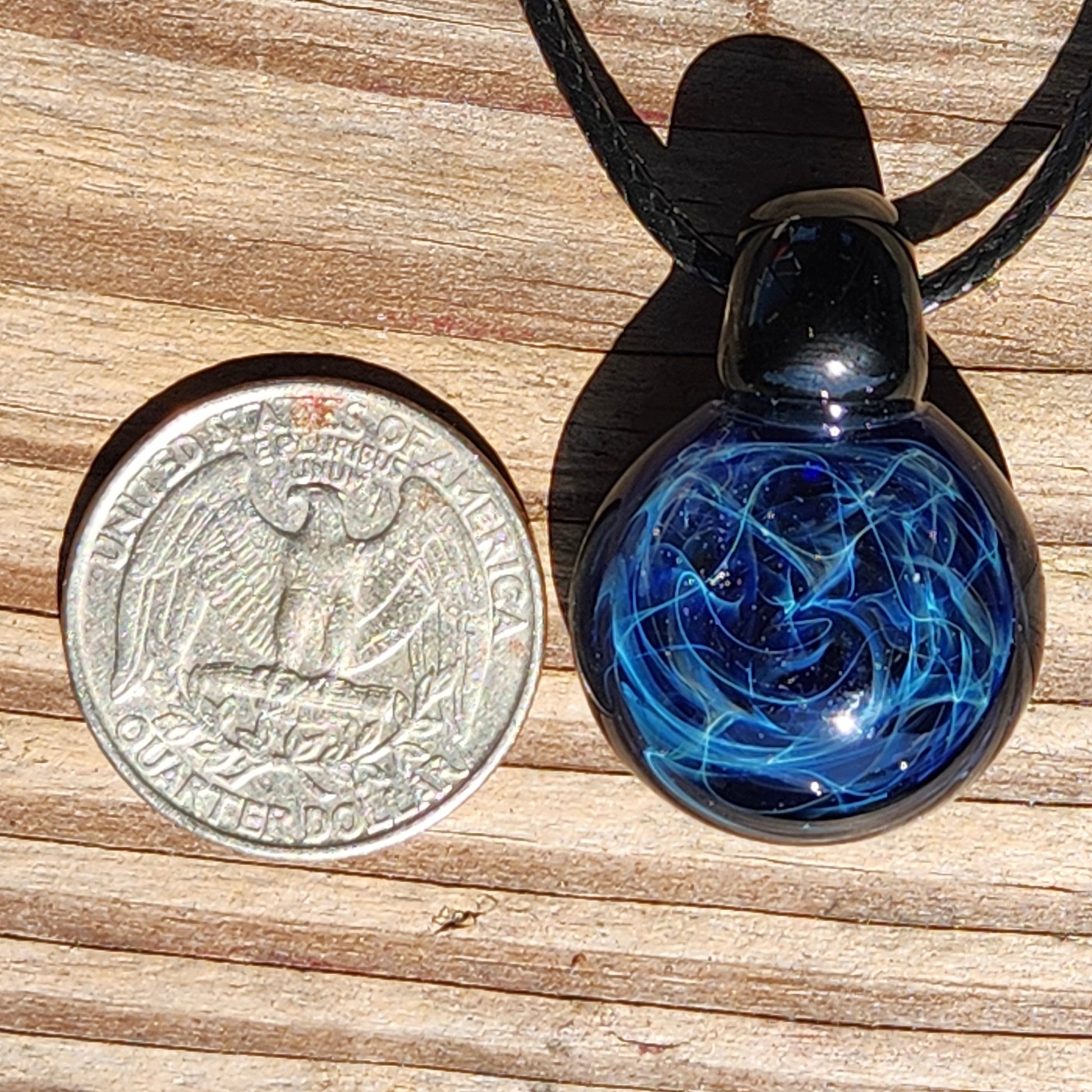 Black glass pendant necklace with deep blue swirling design, handmade artisan jewelry on an adjustable cord, gift boxed
