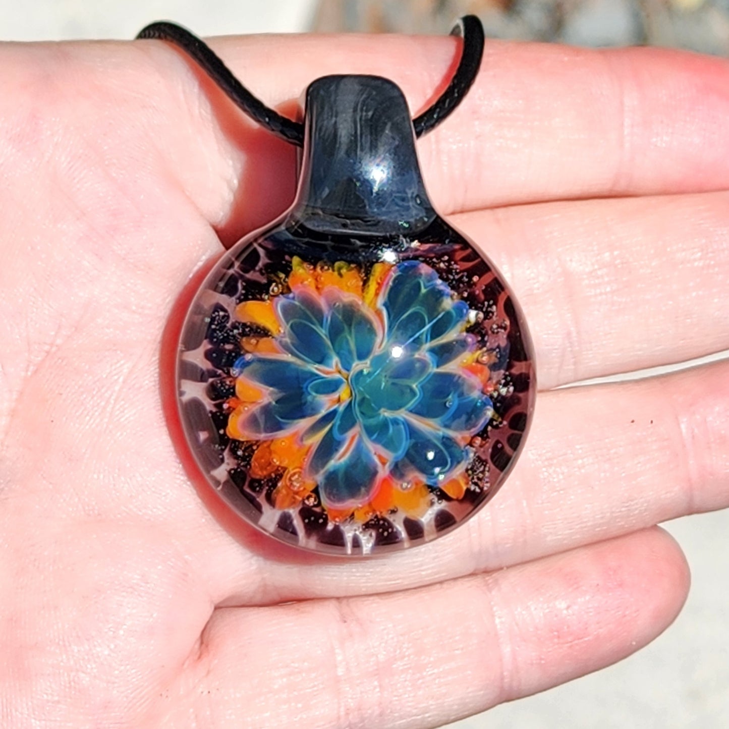 Person wearing the handmade glass flower pendant necklace, focusing on the vibrant colors and craftsmanship.