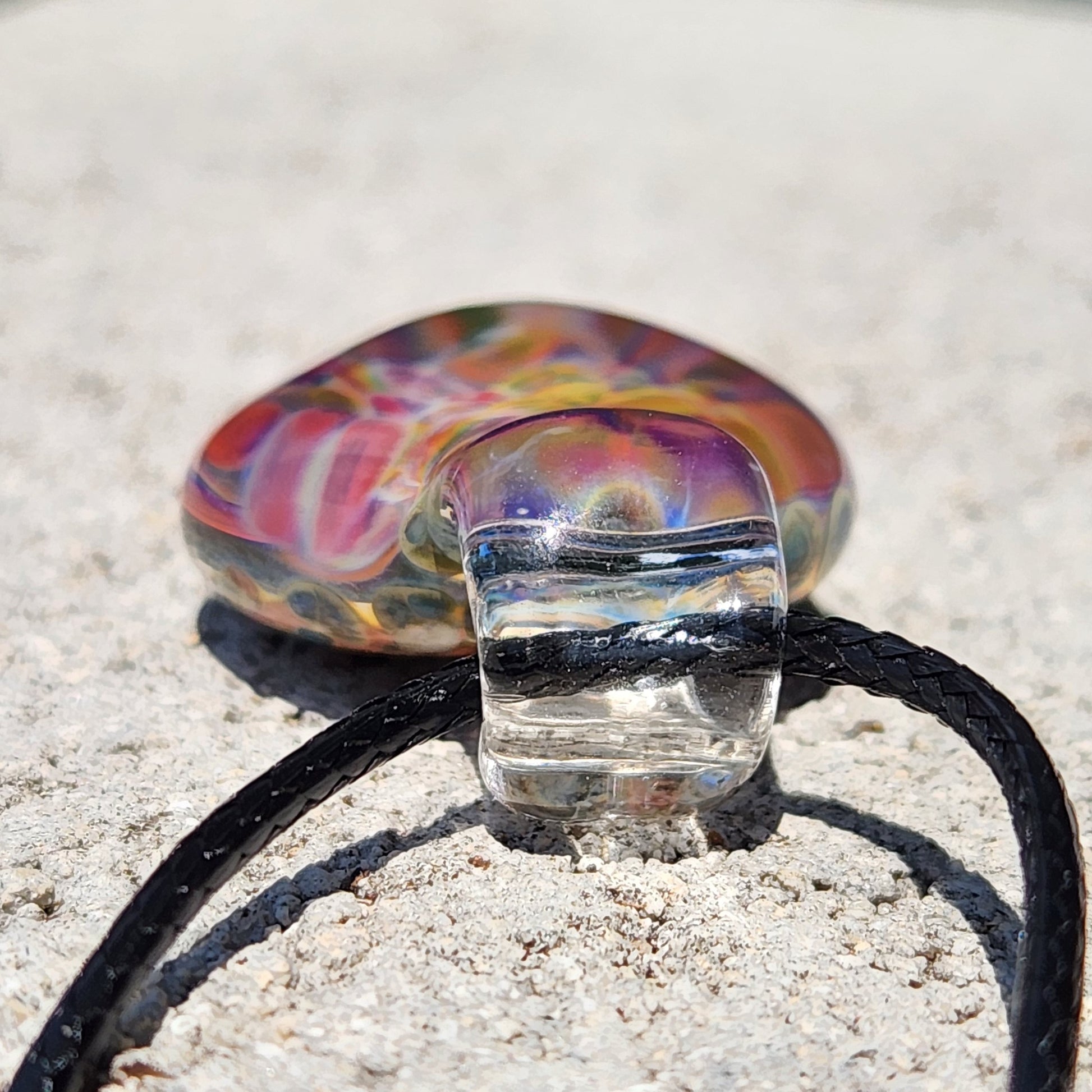 Close-up of the colorful glass pendant with rainbow swirls, showing intricate details and vibrant colors.