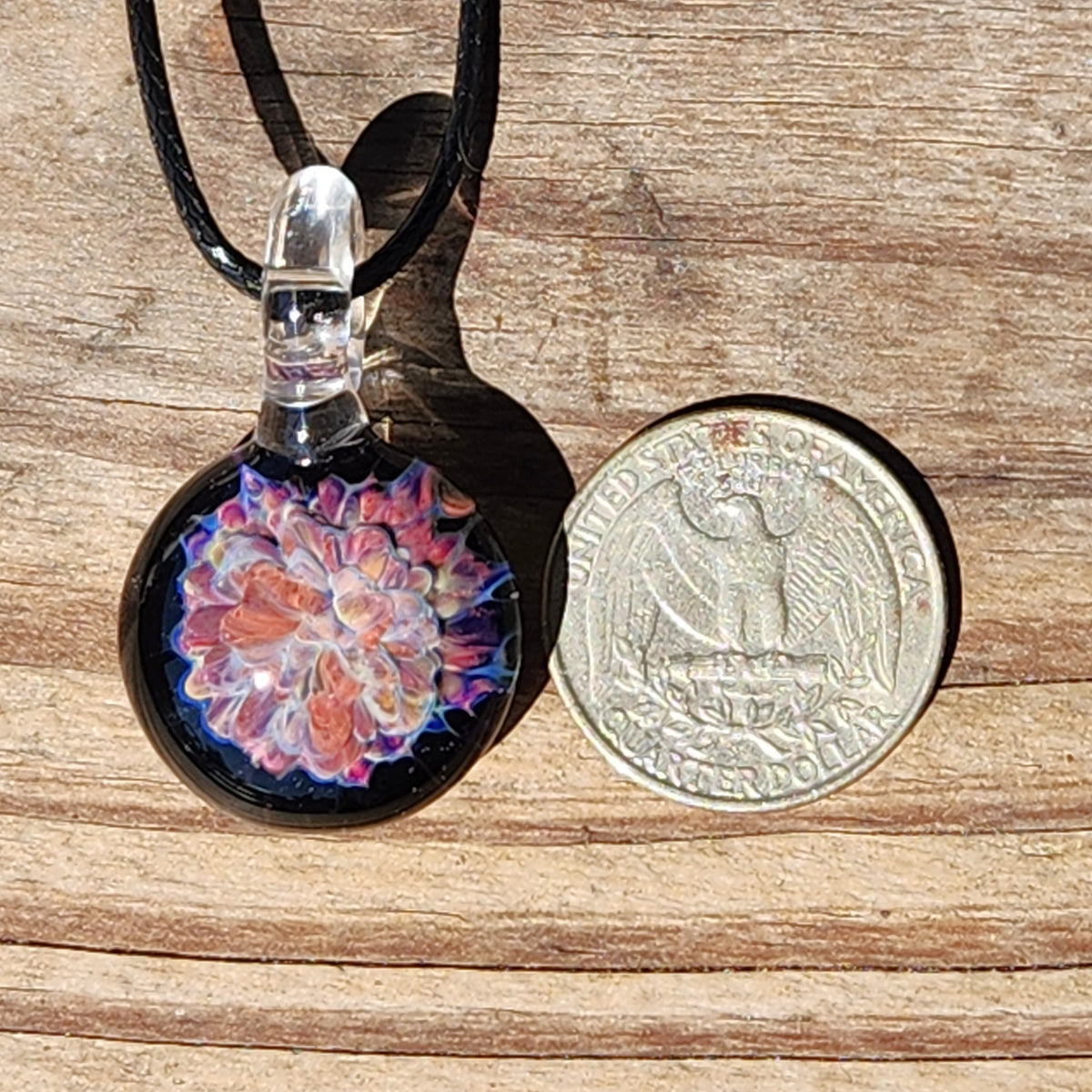 Handmade glass pendant necklace with colorful floral design, black cord, and clear glass accent, perfect for jewelry lovers