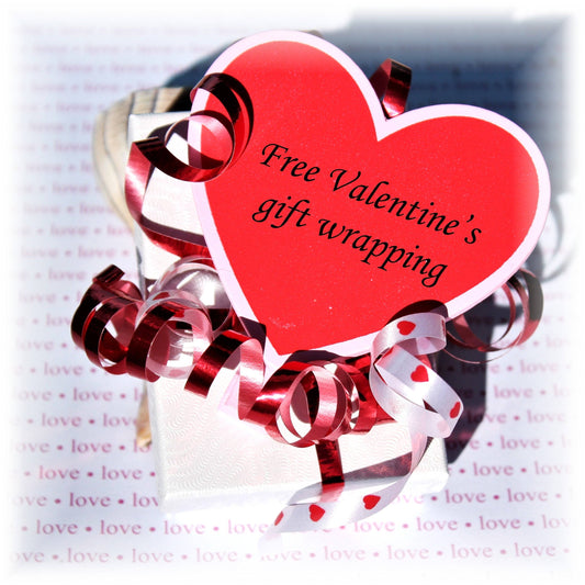 Valentine's Day gift wrapping with a red heart tag and red ribbon curls on a white gift box. Elegant presentation for romantic gifting.