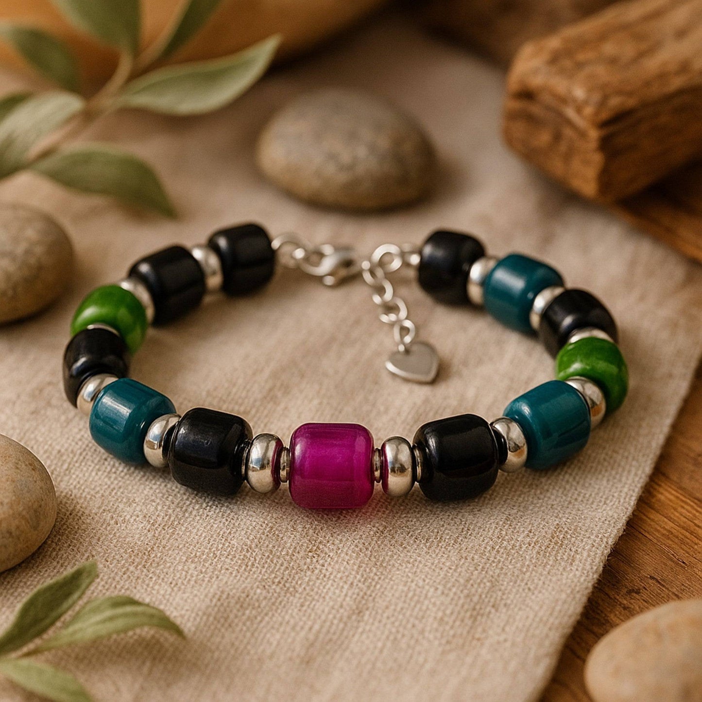 Handmade Boho Glass Beaded Bracelet with colorful beads and silver accents, styled on fabric with natural stones and wood.