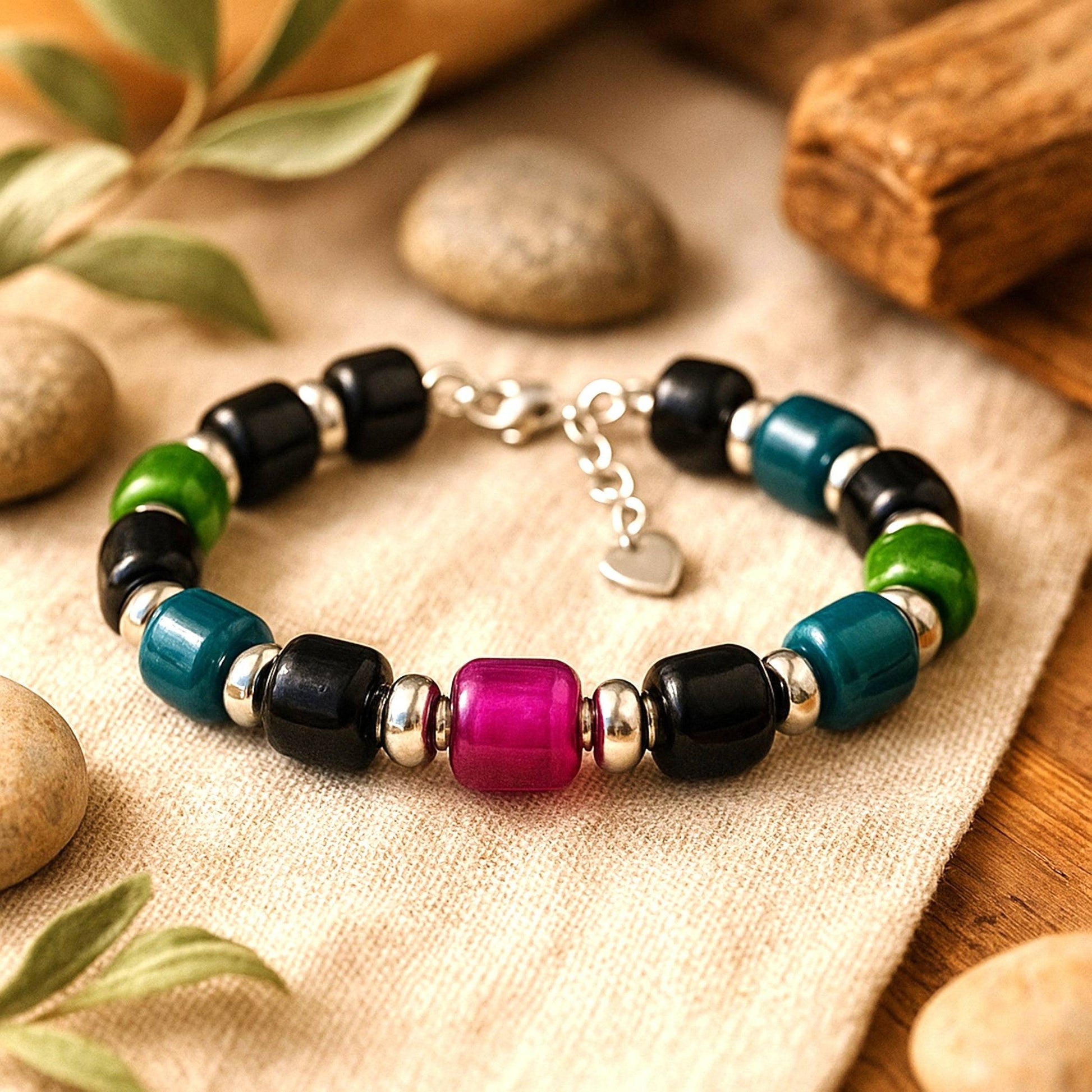 Boho Glass Beaded Bracelet with black, green, blue, and purple handmade glass beads and silver spacers, featuring an adjustable clasp.